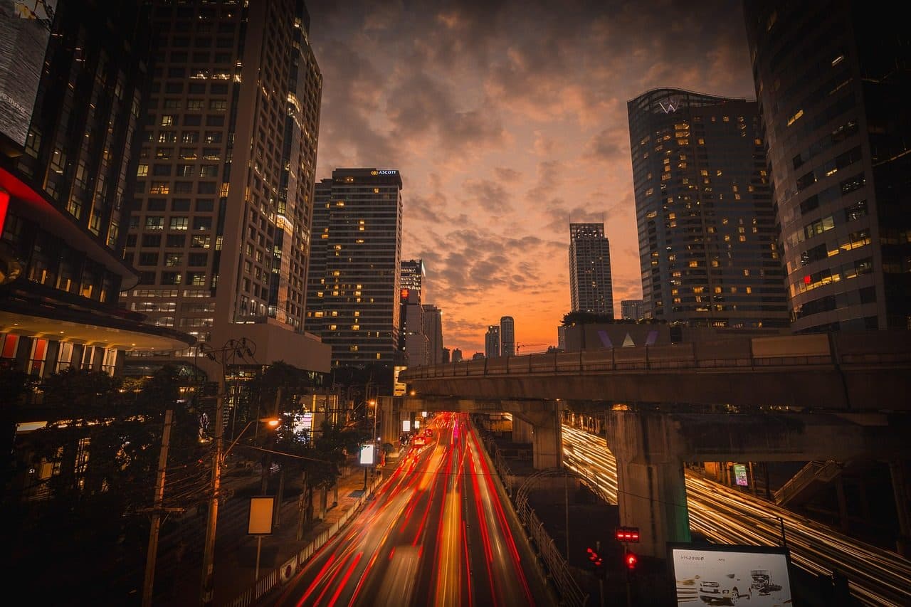 Elevated BTS tracks and office towers at dusk in central Bangkok