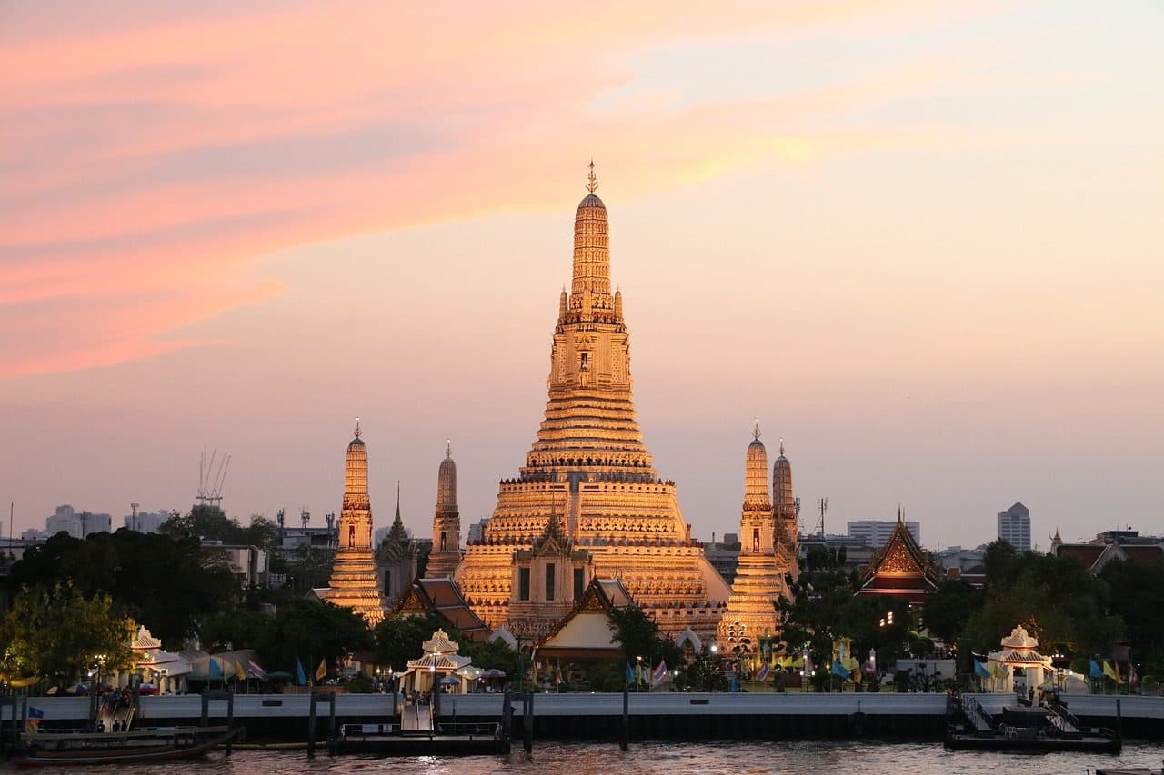 Wat Arun's central prang across the Chao Phraya River at sunset